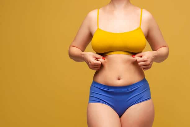 Beauty woman in multicolored underwear on yellow background, body care concept