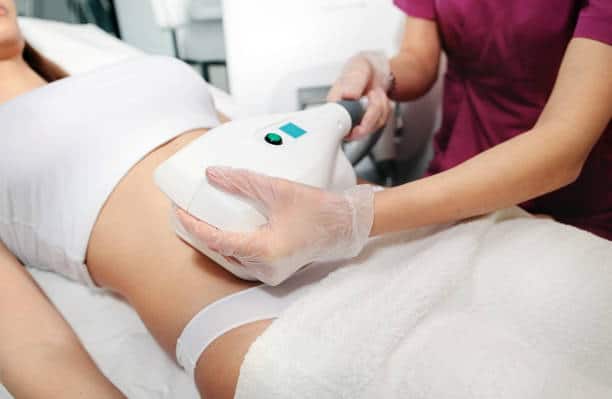 Young attractive woman in white bikini getting Cool sculpting procedure for body slimming.